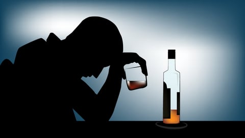 A man depressed with a glass of whisky