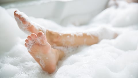 Woman's feet sticking out of a bubble bath