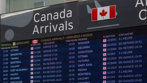 An arrivals board covered with Canadian cities