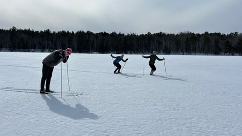 three people on cross country skis in the snow