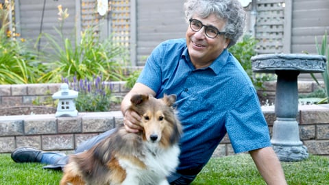 Doctor laying on his lawn outside with his cute dog