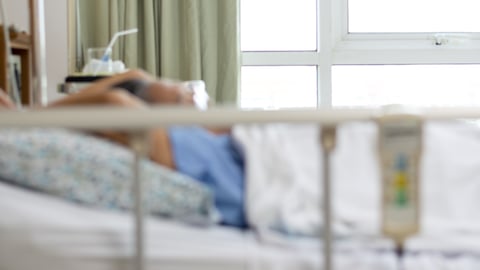 Blurry frame of a woman laying in a hospital bed