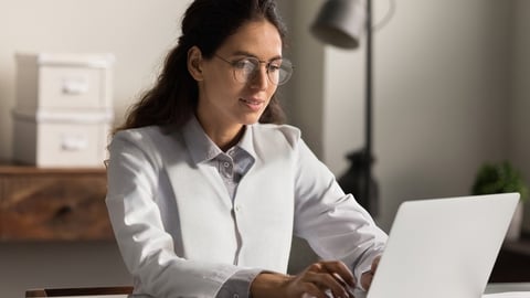 a darker-skinned woman pharmacist at computer