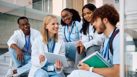 A diverse group of medical students chatting on steps