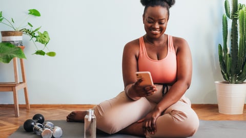 woman of colour sitting on yoga mat