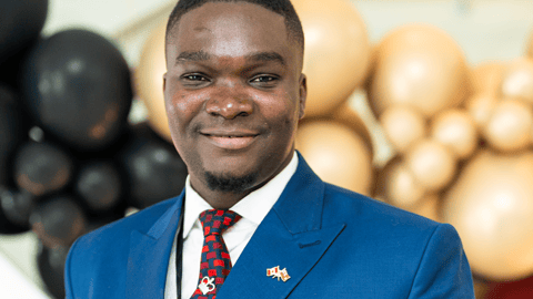 Black man in blue suit with red tie