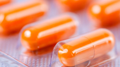 Close up of orange pill capsules in a blister pack