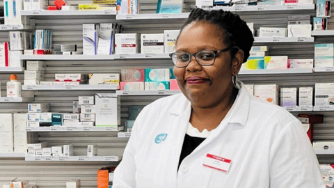 Atai Okokon standing in front of a wall of drugs