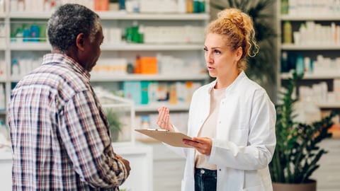 Female pharmacist chatting with older male patient
