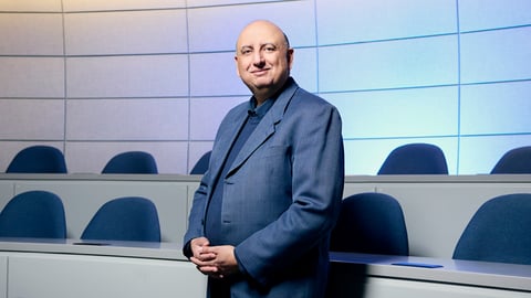 Tarek Hussein standing for a photo in a blue suit