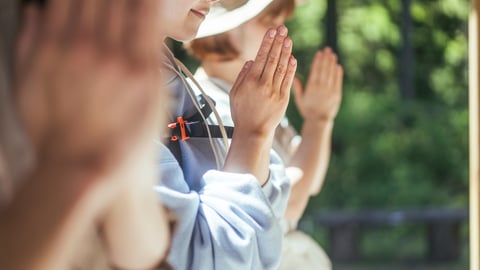 Three people are seen praying at a shrine.