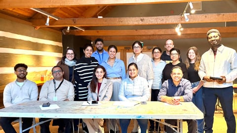 Group of medical residents in professional clothes sitting in a log building.