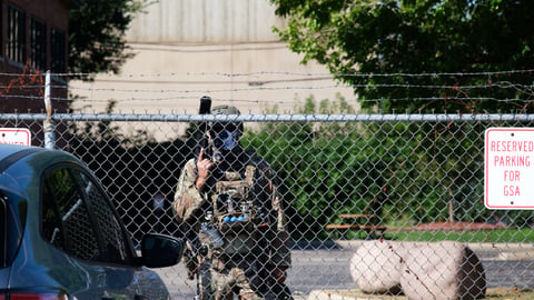 Border police agent stands by fence outside of the Broadview ICE detention Center