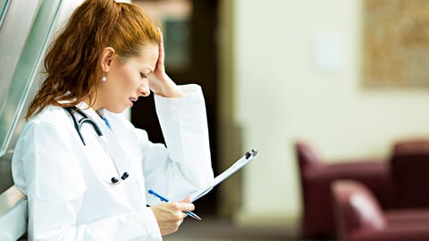 Young woman doctor looking frustrated at a chart