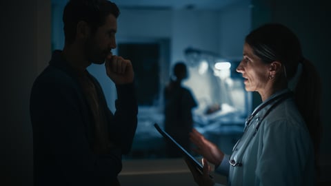 Two doctors standing outside the patient ward.