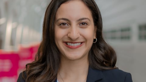 Dr. Alisha Ebrahim, a young physician resident standing in a hall smiling