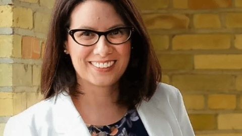 Dr. Debra Evaniuk in a white jacket smiling for a photo