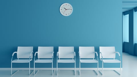 A set of white empty chairs in a clinic waiting room