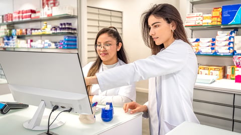 Two pharmacists looking at a computer together 