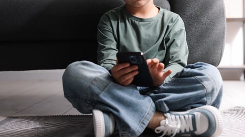 A child looking at a phone, upset.