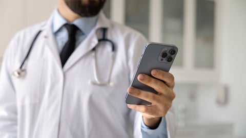 A physician holding a smartphone.