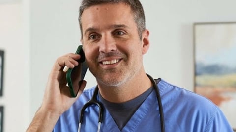 Dr. Daniel Rasic; in scrubs; phone at ear