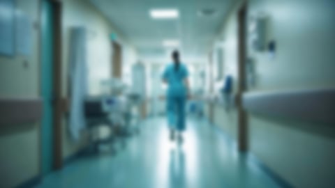 Blurry photo of a female doctor walking down a hospital corridor 