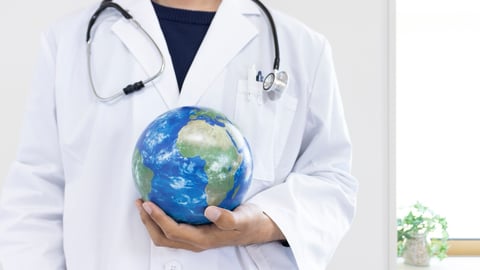 Image of a doctor holding a globe.