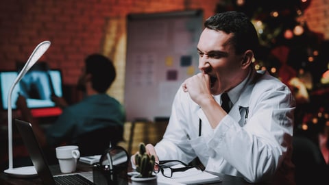 male doctor working holidays yawning