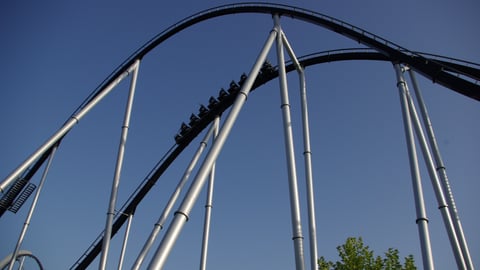 Amusement park attendees ride a roller coaster.