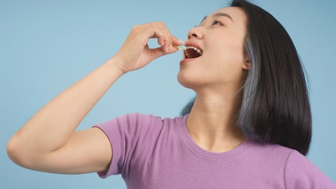 Asian female taking a pill