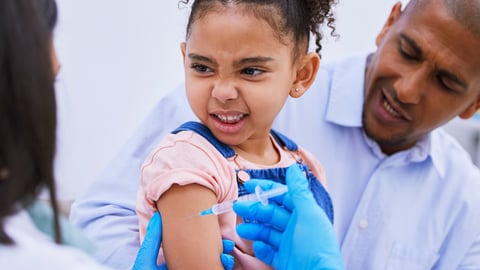 Cute little girl scrunching her face in anxiety about to get a vaccine