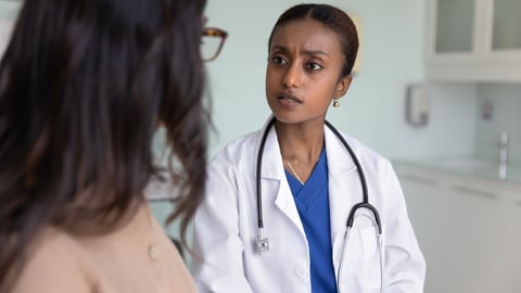 Young woman doctor looking concerned as a patient explains something