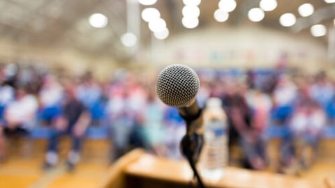 Close up of microphone on a podium in an auditorium; Shutterstock ID 1111824998