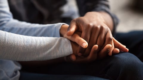 Close up black woman and man in love sitting on couch two people holding hands. Symbol sign sincere feelings, compassion, loved one, say sorry. Reliable person, trusted friend, true friendship concept; Shutterstock ID 1192766194