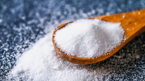 Crystals of shallow salt in a scoop, spoon on a dark gray table. Background for advertising salt. Table salty. Salted food.; Shutterstock ID 1197650182