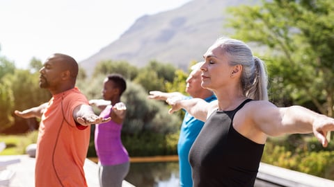 Group of senior people with closed eyes stretching arms outdoor. Mature yoga class doing breathing exercise. Women and men doing breath exercise with outstretched arms. Balance and meditation concept.; Shutterstock ID 1418121728