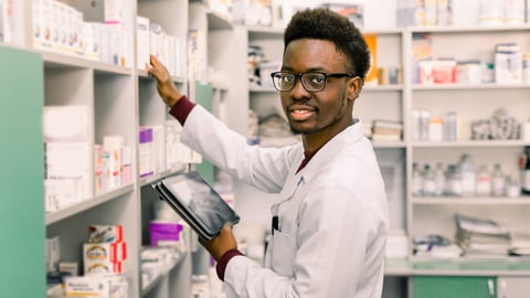 African American male pharmacist using digital tablet during inventory in pharmacy.; Shutterstock ID 1456452980