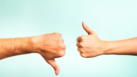 Two hands signalling thumbs up and thumbs down. The smooth hand on the left is making a thumbs up gesture while the hairy hand on the right is making a thumbs down gesture.; Shutterstock ID 153221729