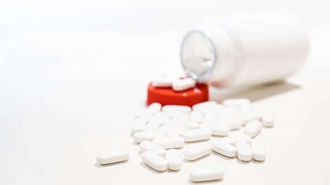 An Isolated Open Flask Bottle of White Pills Spilling Out With Copy Space Over White Background. Controlled substanced in Pharmaceutical Industry. Painkiller Addiction. Tylenol Flask; Shutterstock ID 1691858722