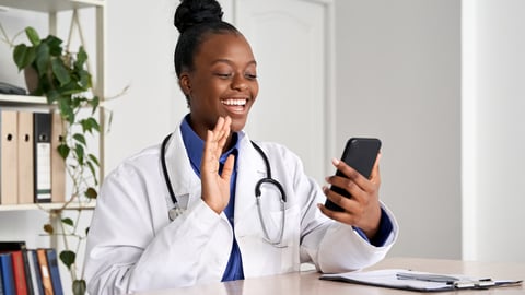 African female doctor holding phone talk to patient make telemedicine online video call. Afro american therapist remote consultation in telemedicine virtual mobile chat application. Telehealth concept; Shutterstock ID 1763113577