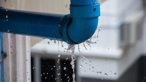 Closeup view of leaked and splash water from the plastic pipe during the rainy day after storm; Shutterstock ID 1831995412
