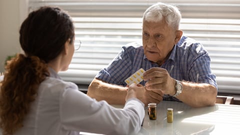 Woman GP or therapist give recommend pills or drugs to unhealthy mature male patient in clinic. Caring female doctor prescribe medicines to sick senior man client. Elderly healthcare concept.; Shutterstock ID 1879850251