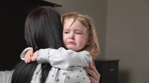 Child is crying in room in the arms of his mother. A loving young mother hugs and comforts her little daughter. Mom calms child. Family mother and baby with tears in their eyes emotionally embrace; Shutterstock ID 1942397095