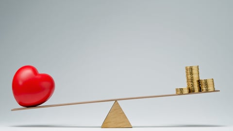 Red heart shape and money coins stack balancing on a seesaw; Shutterstock ID 200537360