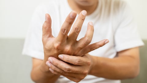 Close up,asian middle-aged man with shaking of Parkinson's disease,symptom of resting tremor,male patient holding her hand to control hands tremor,neurological disorders,brain problems,health care; Shutterstock ID 2049863633