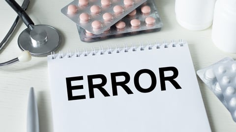 In the notebook is the text ERROR, next to a stethoscope, pills and pen; Shutterstock ID 2070144416