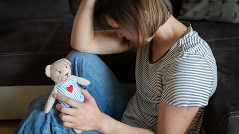 Perinatal loss reproductive chalenge concept - female holding a teddy bear toy; Shutterstock ID 2169899885