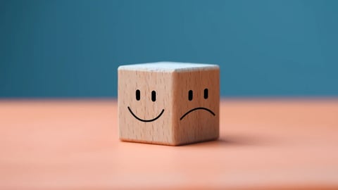 Mental health and emotional state concept, Smile face in bright side and sad face in dark side on wooden block cube for positive mindset selection.; Shutterstock ID 2176918815