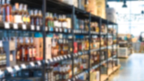 Blur shelves with wine bottles at liquor store as background with copy space. Many blurred bottles with alcohol; Shutterstock ID 2221122677